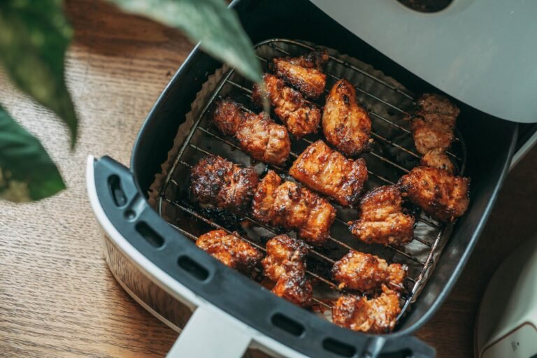 Crispy air-fried chicken pieces on a rack in an air fryer basket