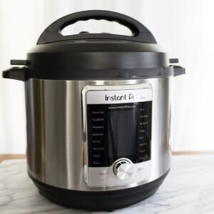 Stainless steel Instant Pot electric pressure cooker on a marble counter