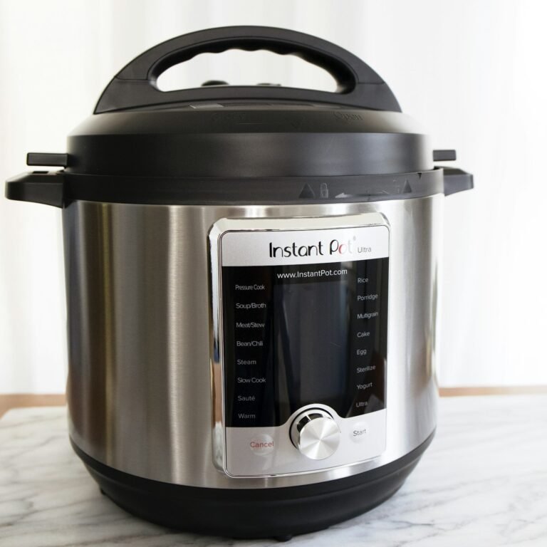 Stainless steel Instant Pot electric pressure cooker on a marble counter