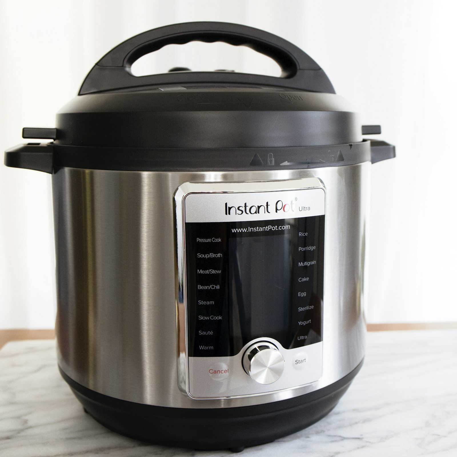 Stainless steel Instant Pot electric pressure cooker on a marble counter
